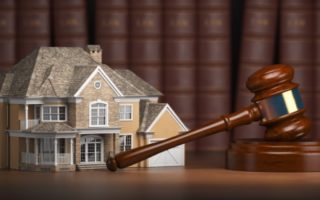 House with gavel and law books.  Real estate law and house auction concept. 3d illustration